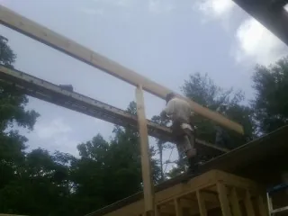 Carpenter setting a ridge beam over a new addition frame — Ice Dam Removal by Roofing Brothers in Harrisonburg
