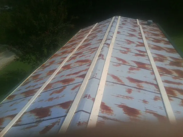 Rusted metal roof panels with new wood purlins before replacement — Storm Damage Roof Repair in Harrisonburg by Roofing Brothers