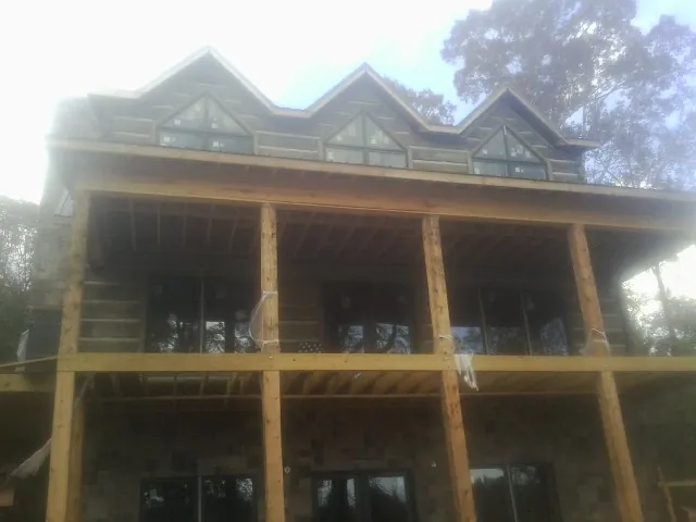 Dormers and porch framing on a large log home under construction — Roof Coating work by our crew in Harrisonburg