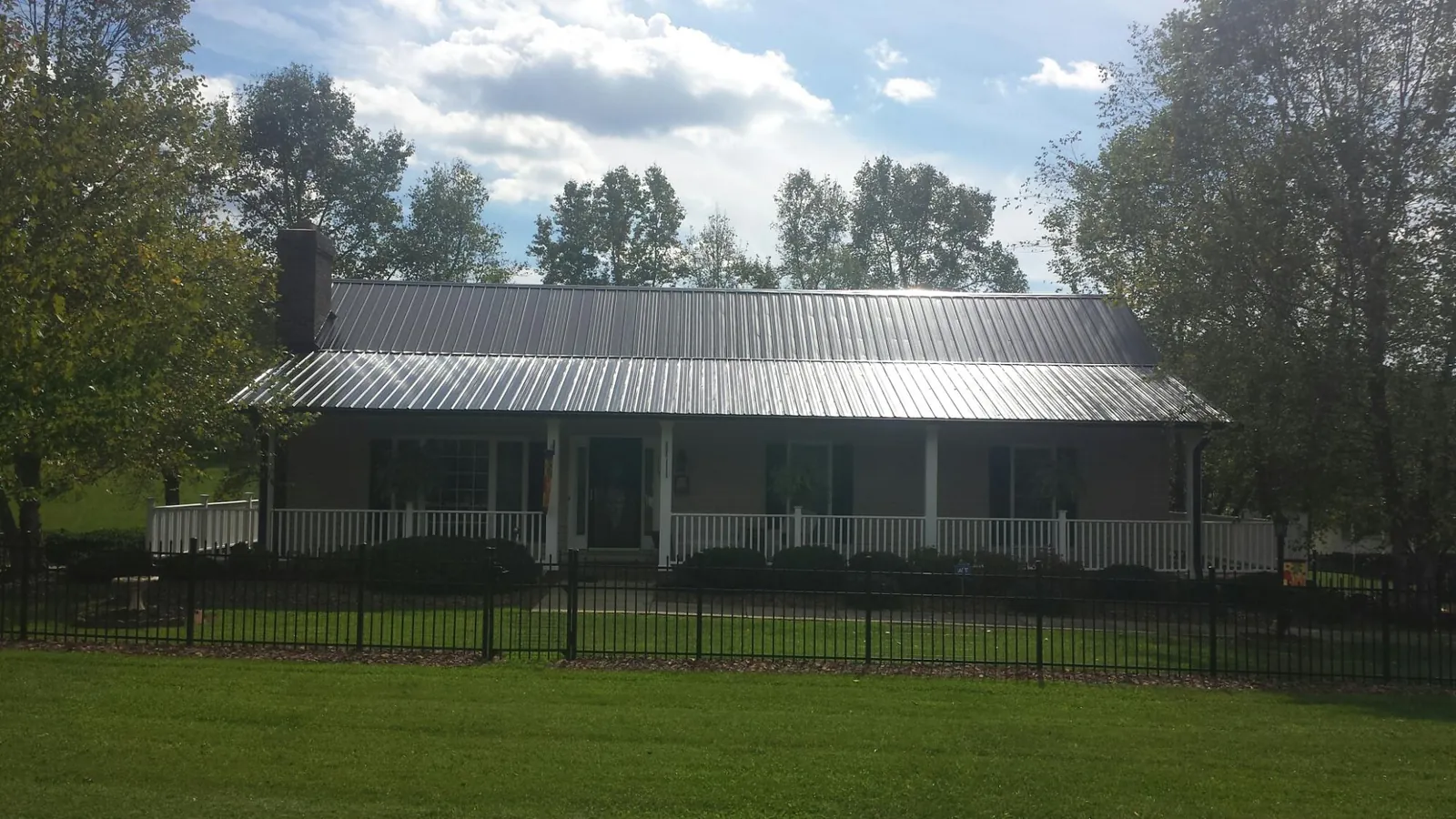 Gray metal roof on a brick ranch with a full width front porch — Gutter Guard Installation work by our crew in Harrisonburg
