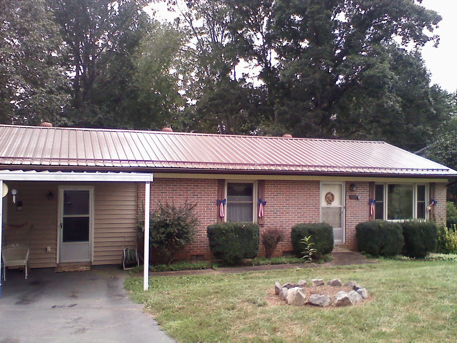 Bronze metal roof and carport on a brick ranch home — Roof Repair work by our crew in Harrisonburg